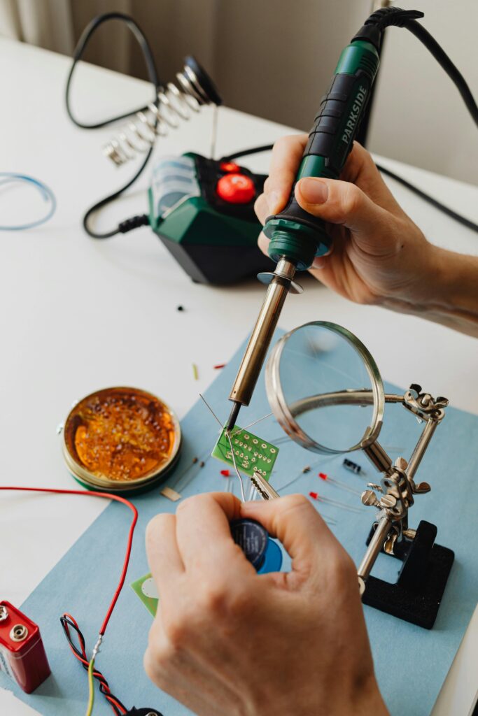 Soldering Iron A soldering iron is forming a connection on an electric board.